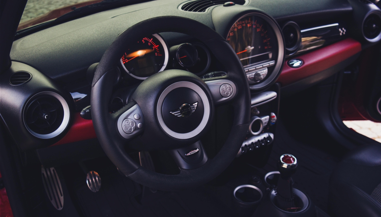 Wnętrze Mini z kierownicą i konsolą; kontekst: wpływ wydechu JCW Pro na brzmienie w kabinie
