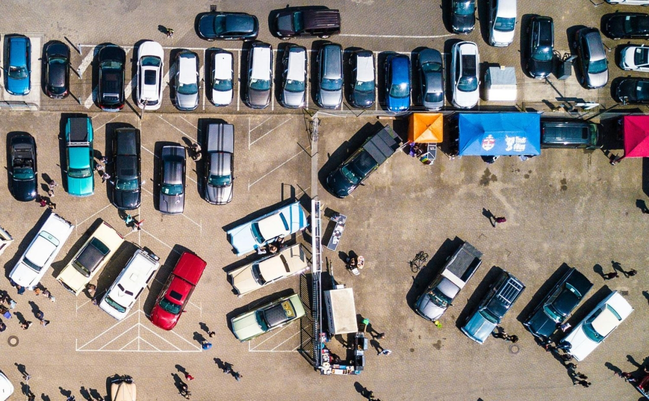 Aerial view of a UK car park with multiple vehicles and stalls; context: how to scrap a car in the UK, best prices, free collection and trusted Certificate of Destruction (CoD)