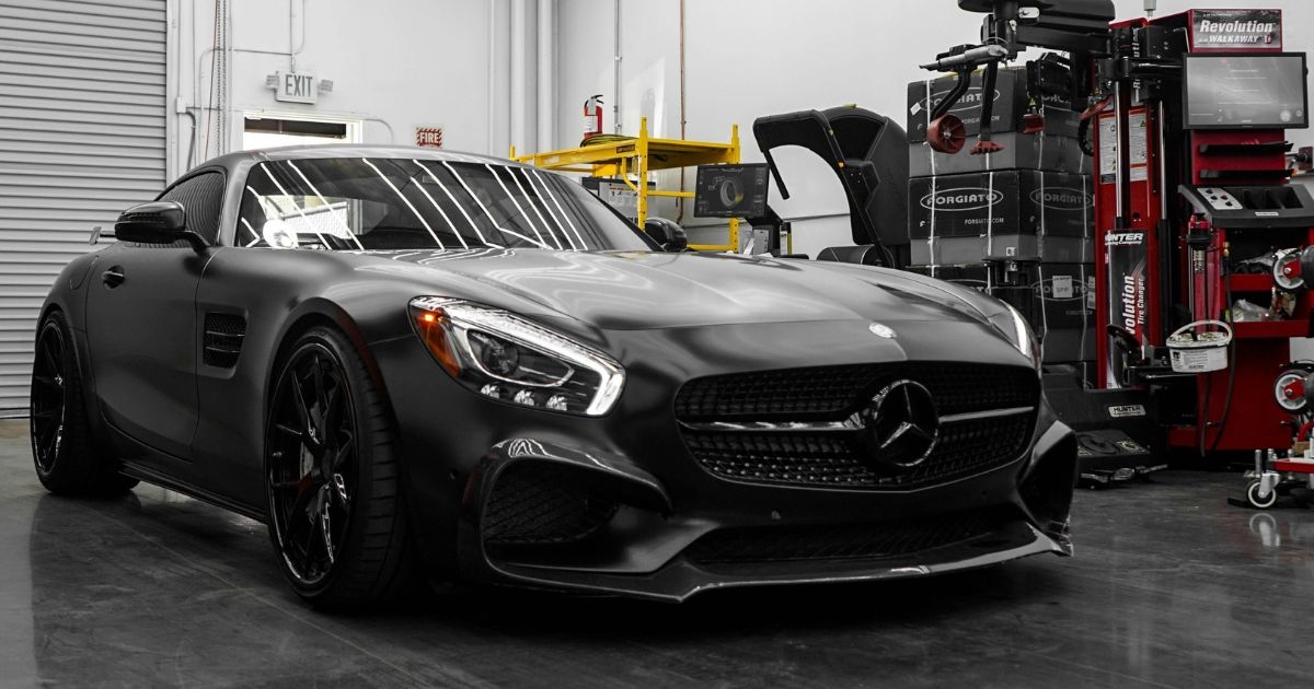 Mercedes-AMG w warsztacie – czarne coupé; ilustracja oferty używanych części Mercedes (silniki, skrzynie, zawieszenie, nadwozie)