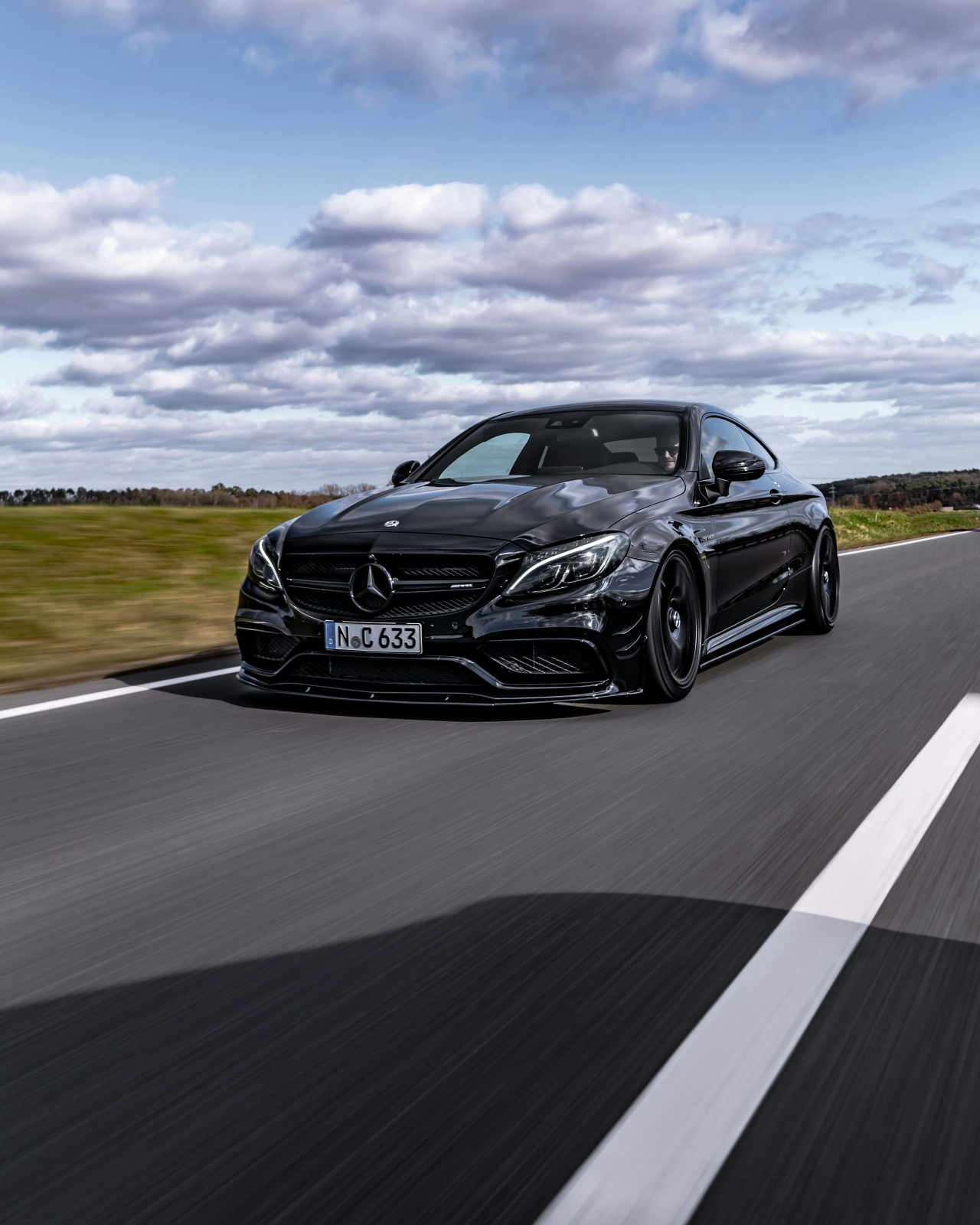 A functioning drive system is the key to enjoying driving your Mercedes. Dynamiczne ujęcie czarnego Mercedesa-AMG C63 jadącego po autostradzie z dużą prędkością.